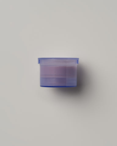 Single purple refill pod for Emma Lewisham Eye Creme against a minimalist gray background.